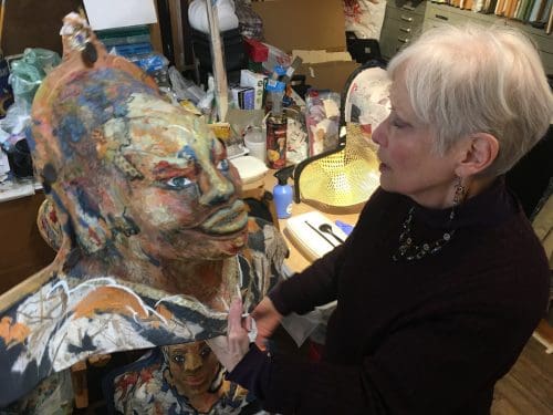 Phyllis Tracy Malinow in studio working on a mask.